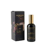 A dark glass perfume bottle with a gold cap stands next to its black packaging box with gold lettering, on a plain white background.